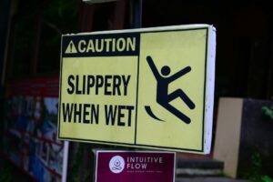 A sign cautions workers about wet surfaces