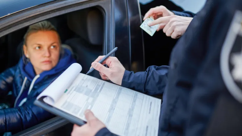 Police patrol checking driver's license of driver