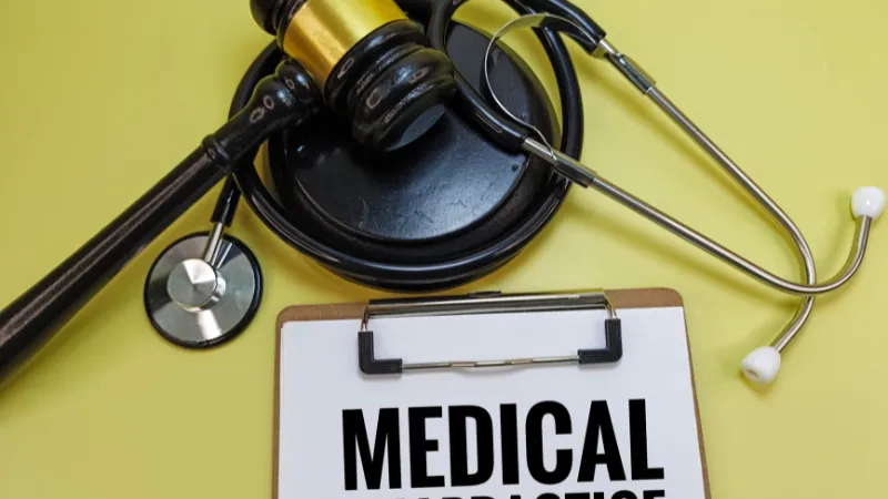 Medical Malpractice on Clipboard with Judge’s Gavel and Stethoscope Representing Healthcare Negligence, Legal Claim, Patient Rights, or Doctor Liability Case.