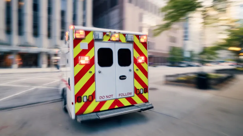 Ambulance car of emergency medical service in blurred motion on city street.